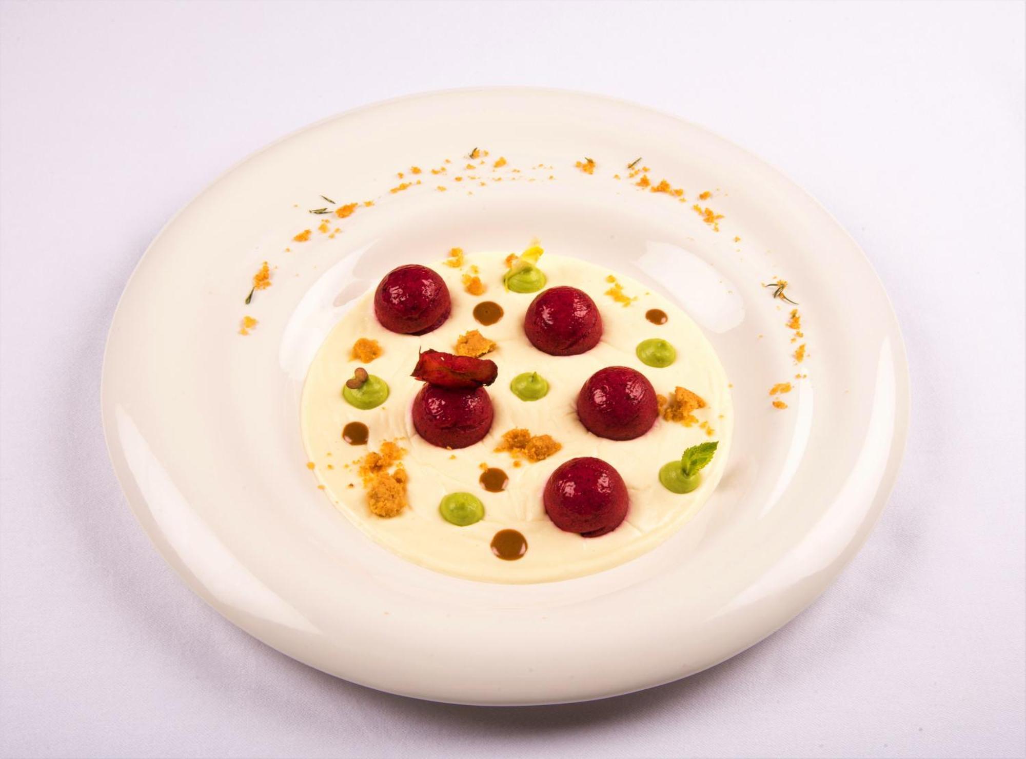 Hotel Bristol Palace Genoa Exterior photo The photo displays a beautifully arranged dish on a white plate. It features several round, glossy items that appear to be garnished spheres, possibly fruit or a mousse-like preparation, in a vibrant red hue. Around these spheres, there are small dol