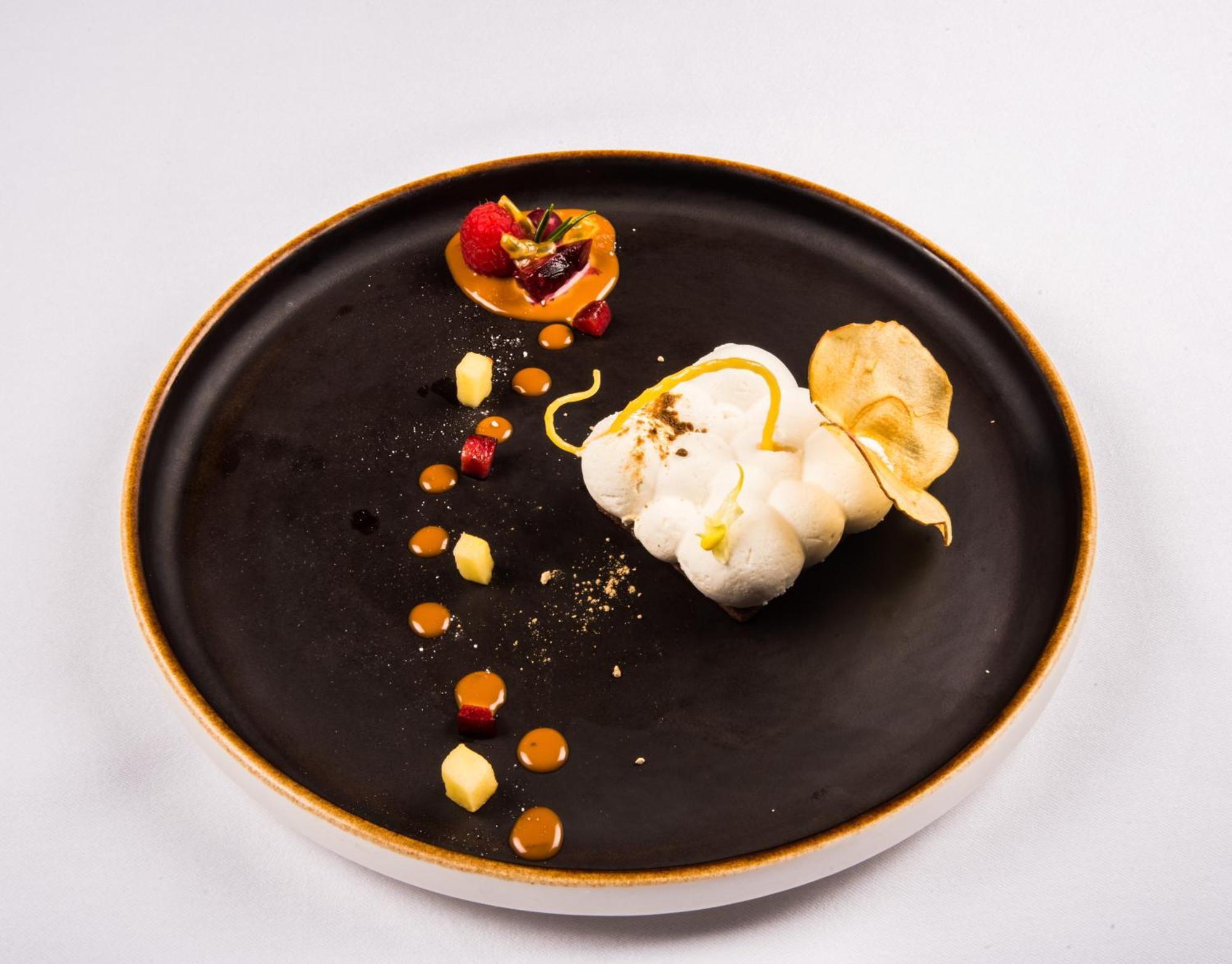Hotel Bristol Palace Genoa Exterior photo The photo features a beautifully arranged plate of gourmet food. On a dark plate, there is a white, fluffy dessert, possibly a meringue or a mousse, that is artistically shaped. Surrounding it are various colorful components, including small dots of 