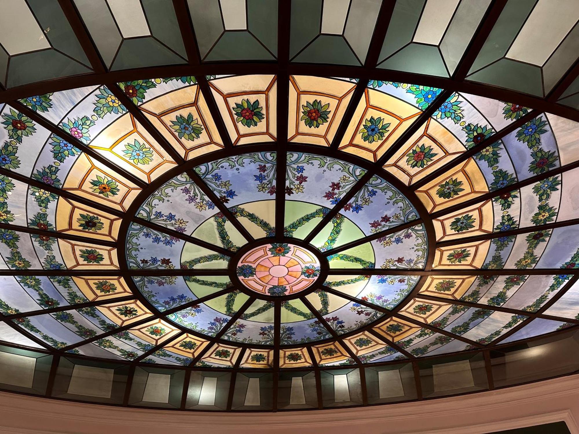 Hotel Bristol Palace Genoa Exterior photo The photo shows a beautifully designed stained glass ceiling. The ceiling features a circular layout with intricate patterns and vibrant colors. It includes floral motifs and geometric shapes, with a central round design that highlights the artistry.